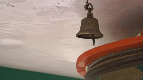 A bell hangs from a chain, swaying gently at Buddhist prayer wheel in Ladakh 库存影片 309330692