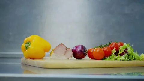 Bell pepper, bacon, onions, tomatoes and lettuce, lying on a wooden stand Stock Footage 70969430