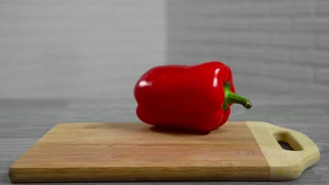 Bell pepper falls on a bamboo cutting board Stock Footage 195523875