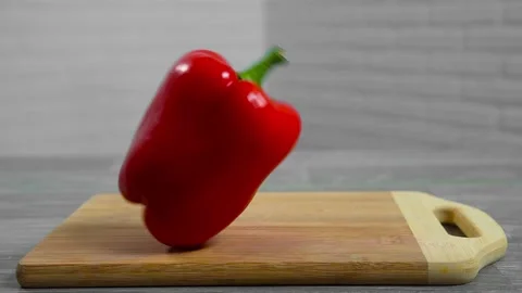 Bell pepper falls on a bamboo cutting board Stock Footage 195523890