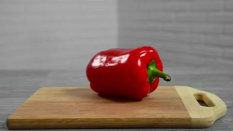 Bell pepper falls on a bamboo cutting board Stock Footage 195523895