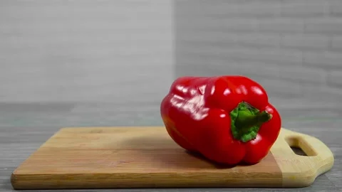 Bell pepper falls on a bamboo cutting board Stock Footage 195523901