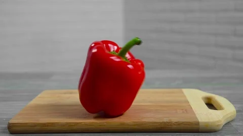 Bell pepper falls on a bamboo cutting board Stock Footage 195523907