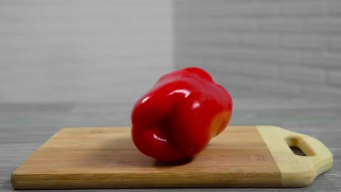 Bell pepper falls on a bamboo cutting board Stock Footage 195523908