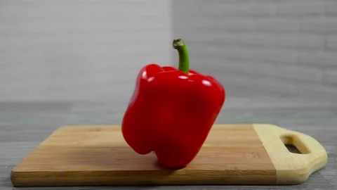 Bell pepper falls on a bamboo cutting board Stock Footage 195523910