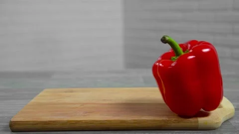 Bell pepper falls on a bamboo cutting board Video stock 195523920