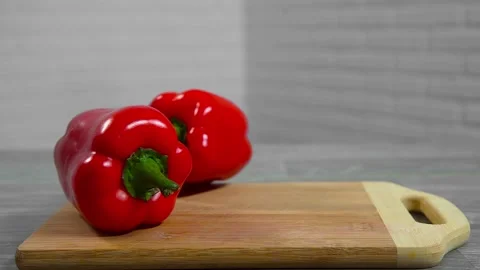 Bell pepper falls on a bamboo cutting board Stock Footage 195523921