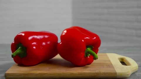 Bell pepper falls on a bamboo cutting board Stock Footage 195523924