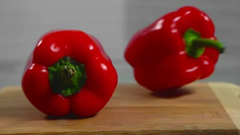 Bell pepper falls on a bamboo cutting board Stock Footage 195523962
