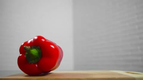 Bell pepper falls on a bamboo cutting board Stock Footage 195523976