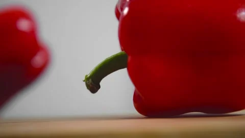 Bell pepper falls on a bamboo cutting board Stock Footage 195523986