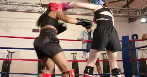Bell spurring Two female boxers sparring in boxing ring, trading feints, jabs Stock Footage 335927049