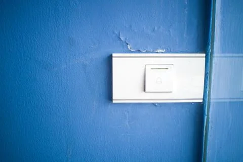 Bell switch button on the blue wall. Stock Photos