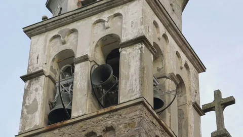 A bell ting on bell tower on top of a church in the Italian mountains Stock Footage 79018544