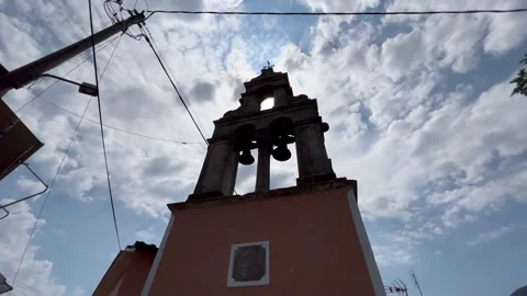 Bell tower against a cloudy sky with power lines overhead Stock Footage 345259448