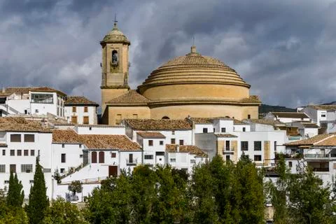 Bell tower and domed roof of Iglesia de la Encarnacion church with white houses Stock Photos