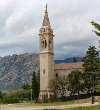 The bell tower on a background of mountains in cloudy weather in Stock Photos