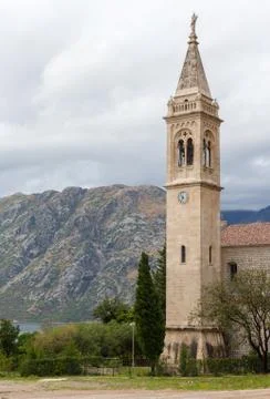 The bell tower on a background of mountains in cloudy weather in Kotor Stock Photos