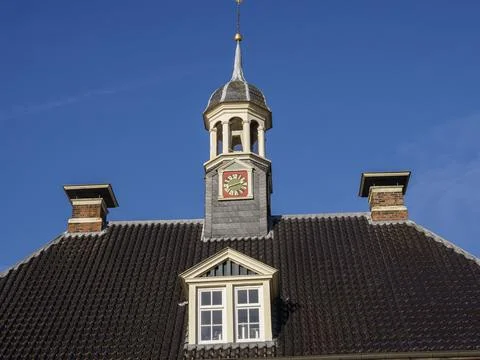 Bell tower on an old building with a clock face in front of a clear blue sky, Fotos de archivo