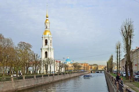 Bell tower of St. Nicholas naval Cathedral and a pleasure boat on the water o Stock Photos