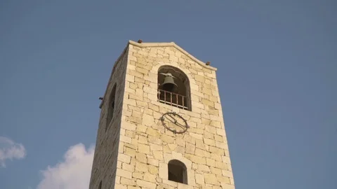 A bell tower in a stabilized zoom shot that revolves around the building Video stock 128661430