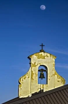 Bell tower under a full moon and a blue sky Stock Photos