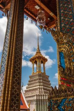 The bell tower viewed from under an arch over a blue sky at the Wat Phra Kaew Stock Photos