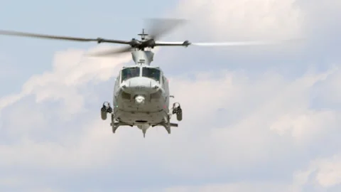A Bell UH-1 Huey attack helicopter hovers Stock Footage 239365152