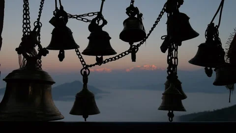 Bells with a backdrop of snowcapped mountains seen from a roof of a temple Stock Footage 336384174