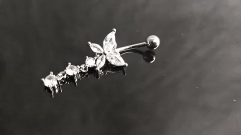 Belly button earrings with stones and a pendant in the shape of cannabis leaves. Stock Footage 309186472