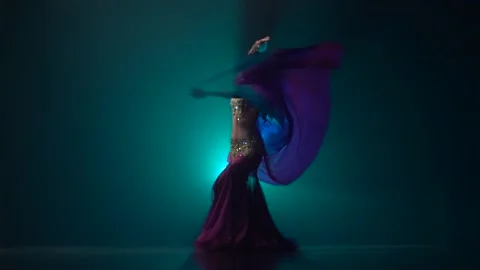Belly dancer girl continue dance uses fans. Smoke background. Slow motion Video stock 105033114