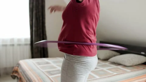 Belly exercise with hula hoop. Overweight female twirling hula hoop. Stock-Footage 161745774