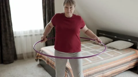 Belly exercise with hula hoop. Overweight female twirling hula hoop. Stock-Footage 161745996