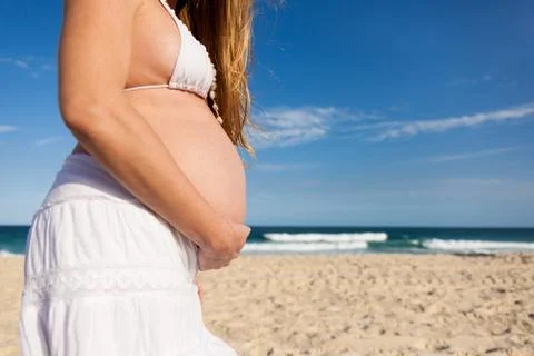 Belly of pregnant woman on beach Stock Photos