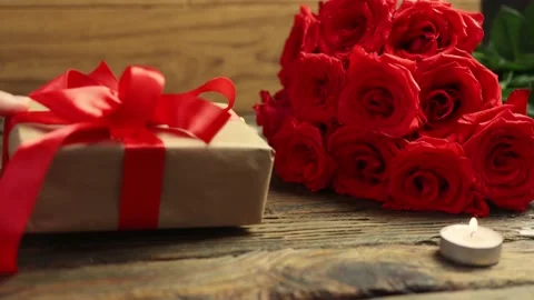 Beloved gift box bunch red roses burning candles wooden table Valentine's Day Stock Footage 166560360