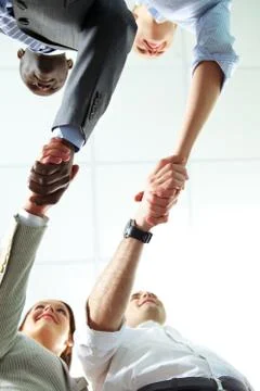 Below angle of two pairs of successful associates handshaking Stock Photos