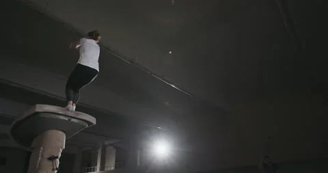 From below back view of young female gymnast jumping from vault and performing Stock Footage 138760392