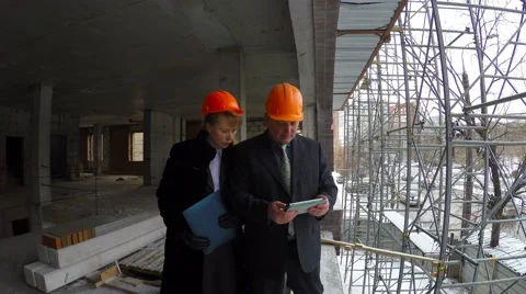 Below drive cars. Unrecognizable builder in orange vest brings boss telephone. Video stock 58686036