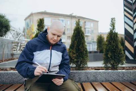 From below of hipster man using modern tablet with stylus while creating new Stock Photos