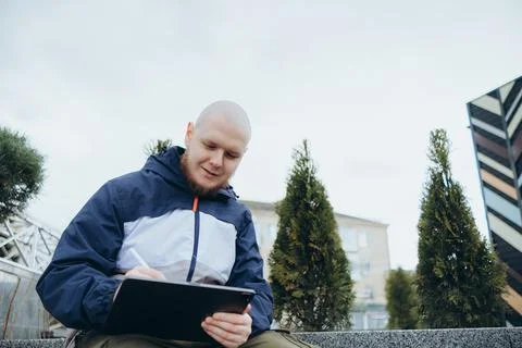 From below of hipster man using modern tablet with stylus while creating new Foto stock