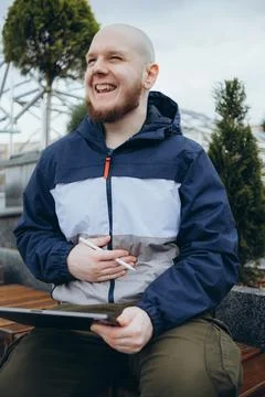 From below of hipster man using modern tablet with stylus while creating new Stock Photos