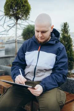 From below of hipster man using modern tablet with stylus while creating new Stock Photos