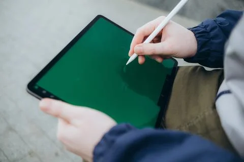 From below of hipster man using modern tablet with stylus while creating new Foto stock