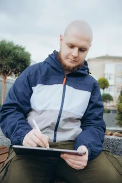 From below of hipster man using modern tablet with stylus while creating new Foto stock