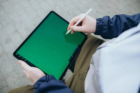 From below of hipster man using modern tablet with stylus while creating new Stock Photos