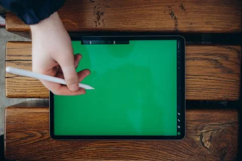 From below of hipster man using modern tablet with stylus while creating new Stock Photos