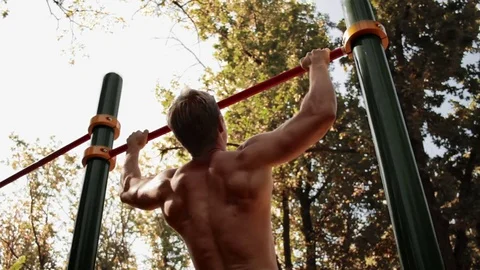 From below view of man doing chin-ups Vidéo 77875801