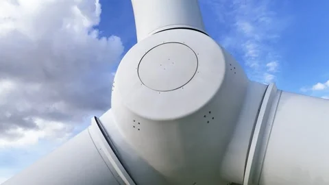Below wind turbine hub circular central cap white blades extending framed by Stock Footage 329091913