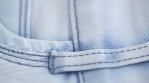 Belt loop and pocket on denim trousers closeup.  light blue jeans rotation. Stock Footage 242420964