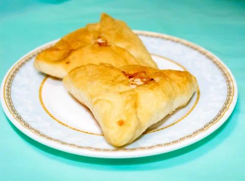 Belyashi. Fried Triangular pies with meat on a plate. Stock Photos